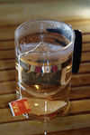 Bag of puerh <span class='translation'>(Pu Er tea)</span> tea brewed in a glass mug