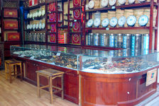 Shop Lijiang, in the foreground and jade jewelry wood in the background puerh <span class='translation'>(Pu Er tea)</span> cakes 