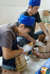 Women compressing puerh <span class='translation'>(Pu Er tea)</span> patties at Chen Sheng Hao