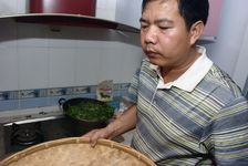 Mr Luo Hou You travaillant des feuilles de thé sans sa cuisine