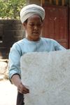 Femme Dai avec une feuille fraîchement fabriquée