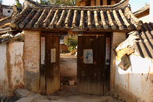 Portail protégé par l'éfigie de Menn Shen dans un village de Lincang, Yunnan